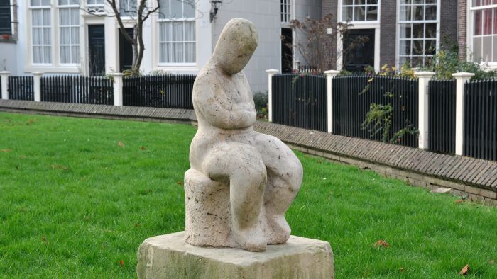 Zittende vrouwenfiguur met gekruiste armen