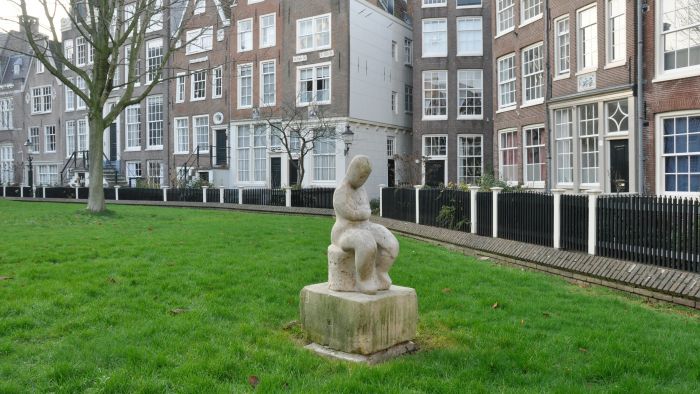 Zittende vrouwenfiguur met gekruiste armen